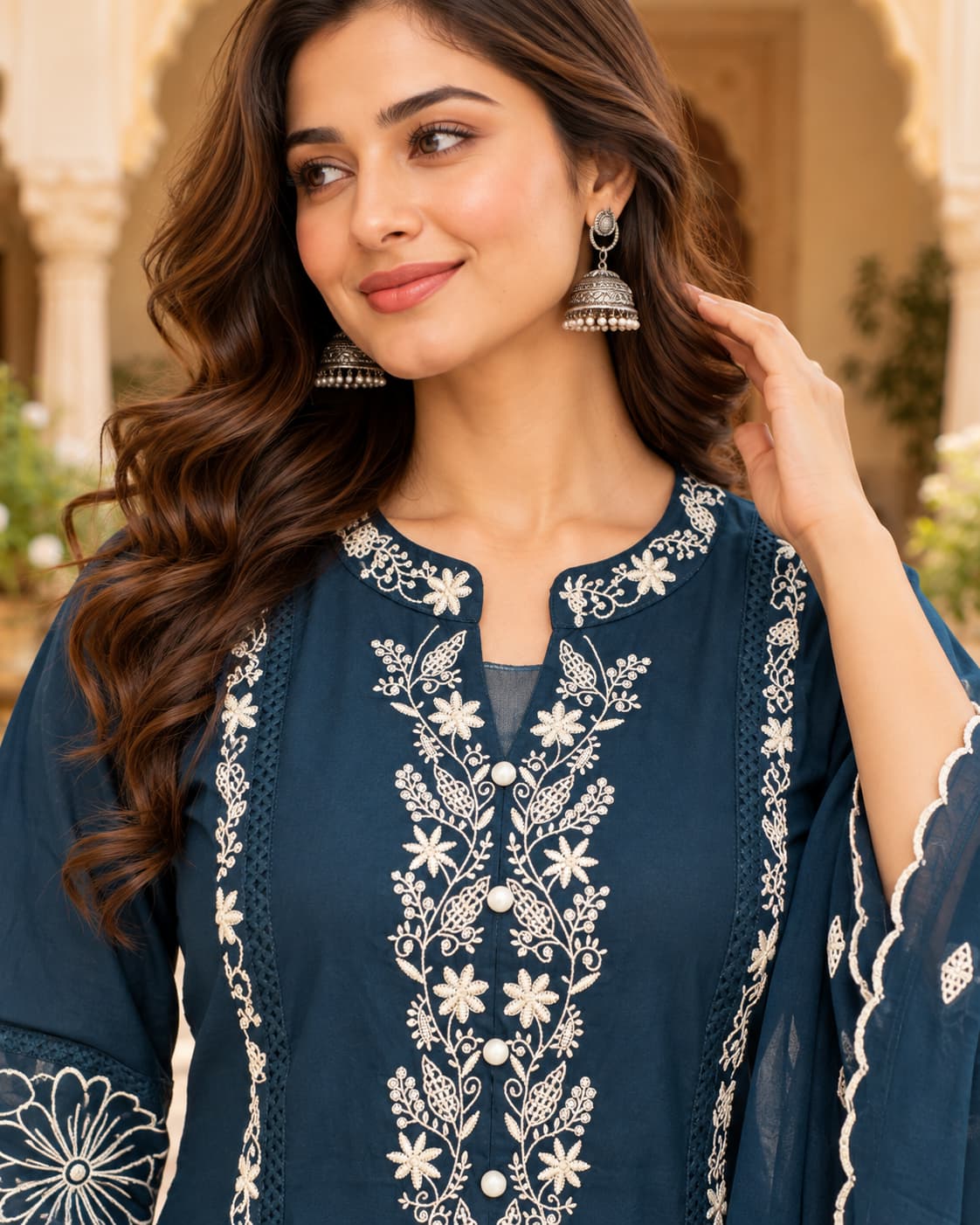 Ivory floral embroidery detail on a peacock blue kurta