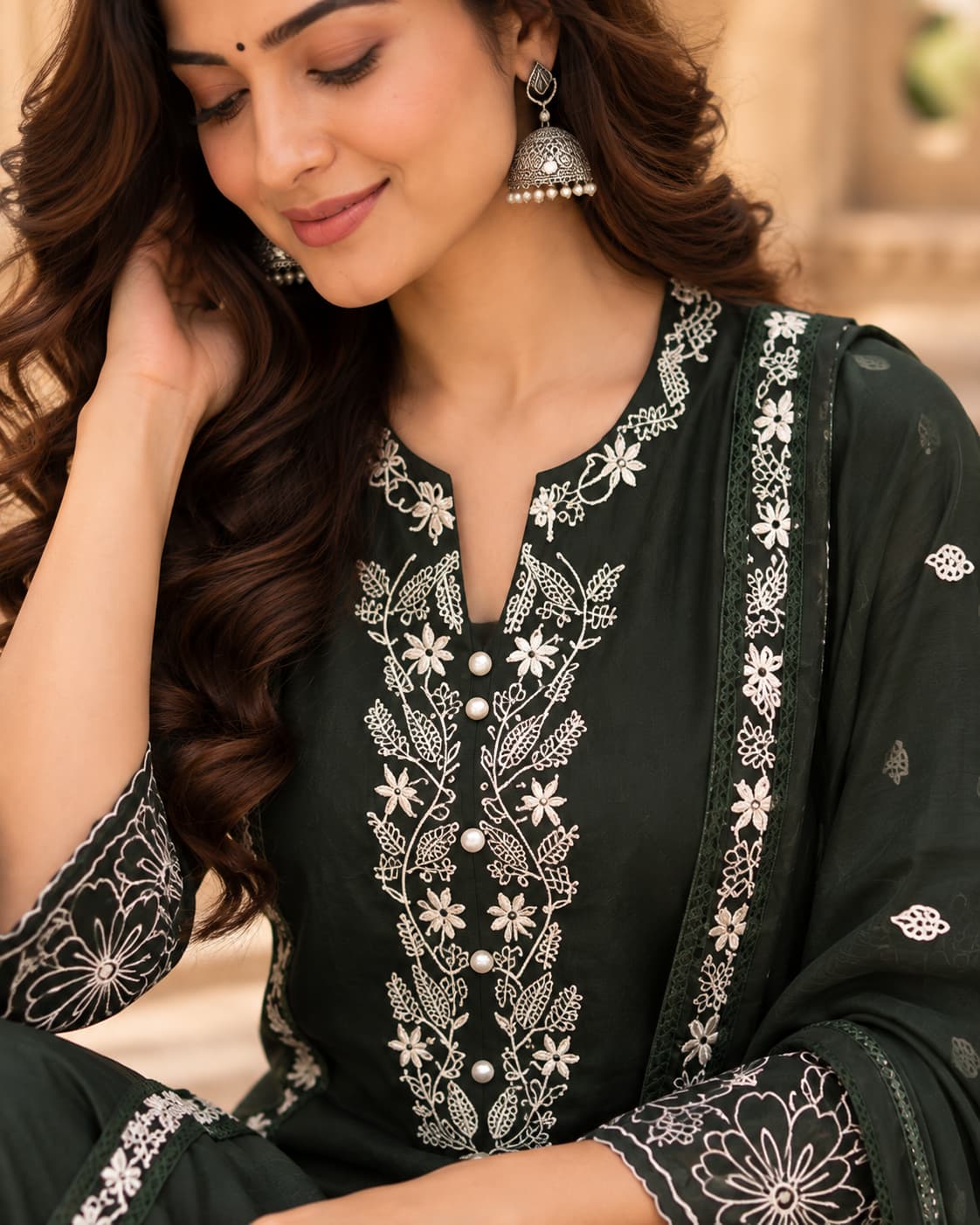 Ivory floral embroidery detail on a deep green kurta