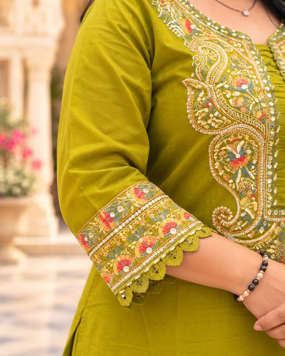 Close-up of embroidery on the sleeve of a mehendi green cotton kurta