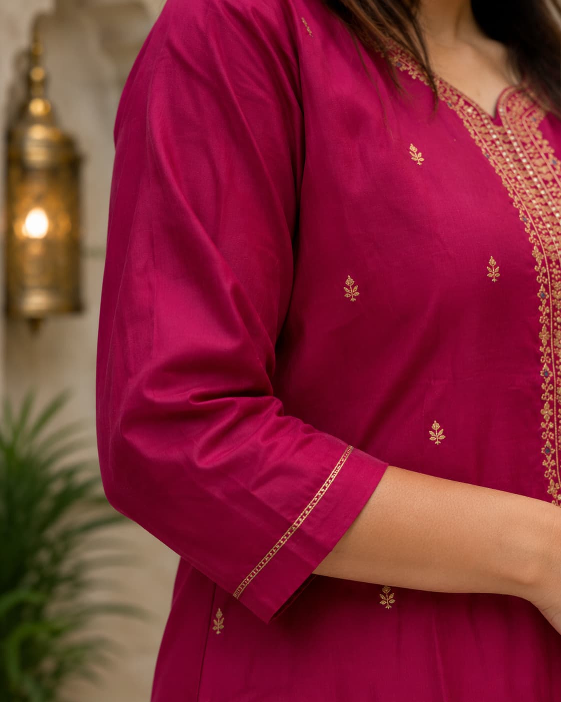 Golden zari-look thread work detail on the yoke of the magenta kurta