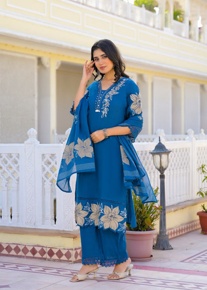 Three-piece blue floral embroidered kurta set with dupatta draped, full-length view